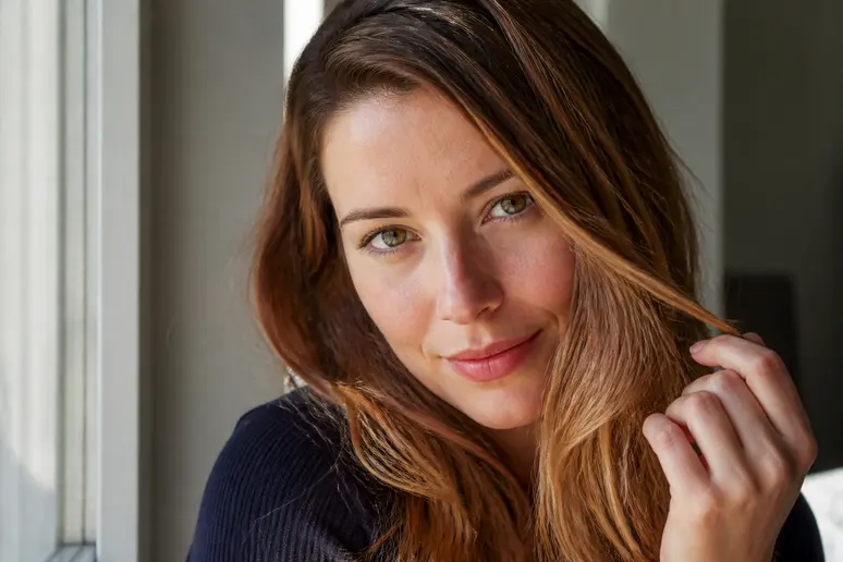 Jeune femme choisit sa nuance idéale de couleur-cheveux-automne pour sa carnation.