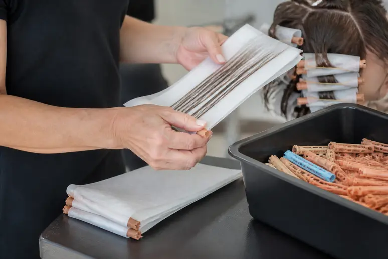 Utilisation de papiers pointes et d'accessoires pour la pose de bigoudis.