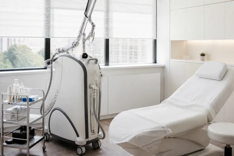 Appareil laser dermatologique moderne installé dans une cabine de soin esthétique professionnelle