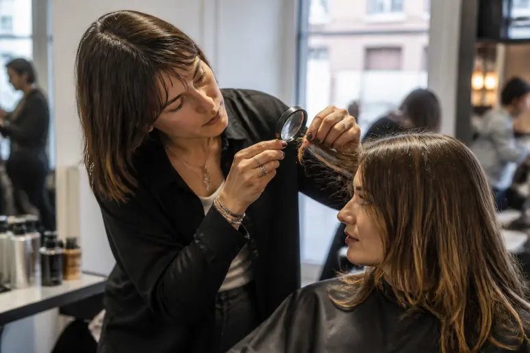 Diagnostic capillaire pour choisir coiffeur Lille : analyse minutieuse des cheveux par un expert.