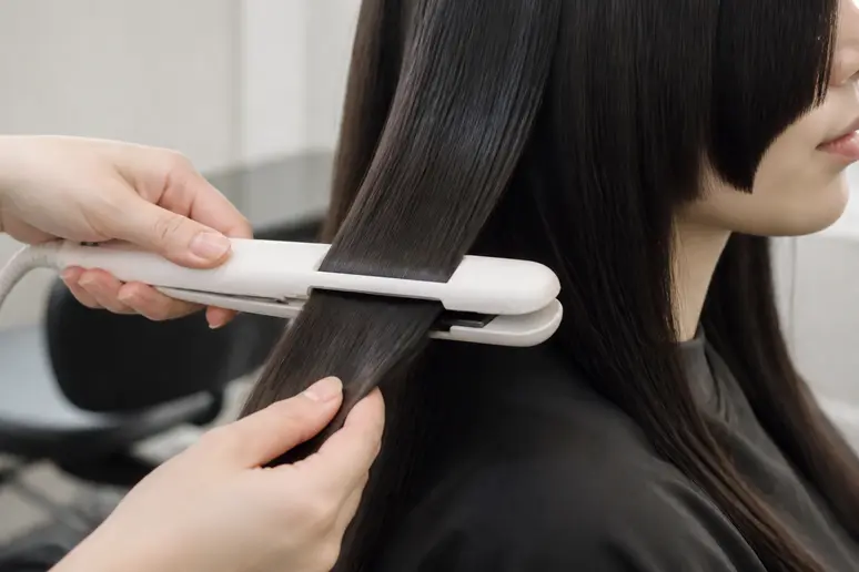 Lissage minutieux des cheveux longs pour entretenir une hime cut sans frange