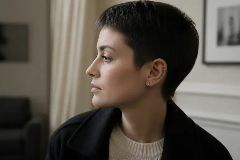 Profil d'une personne montrant une composition asymétrique de piercings sur l'oreille gauche