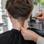 Jeune personne montrant une queue de rat coiffure originale vue de dos dans un salon moderne