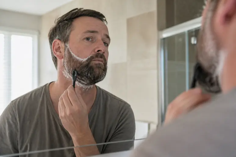 Application minutieuse d'une teinture de barbe pour un résultat impeccable sans taches.