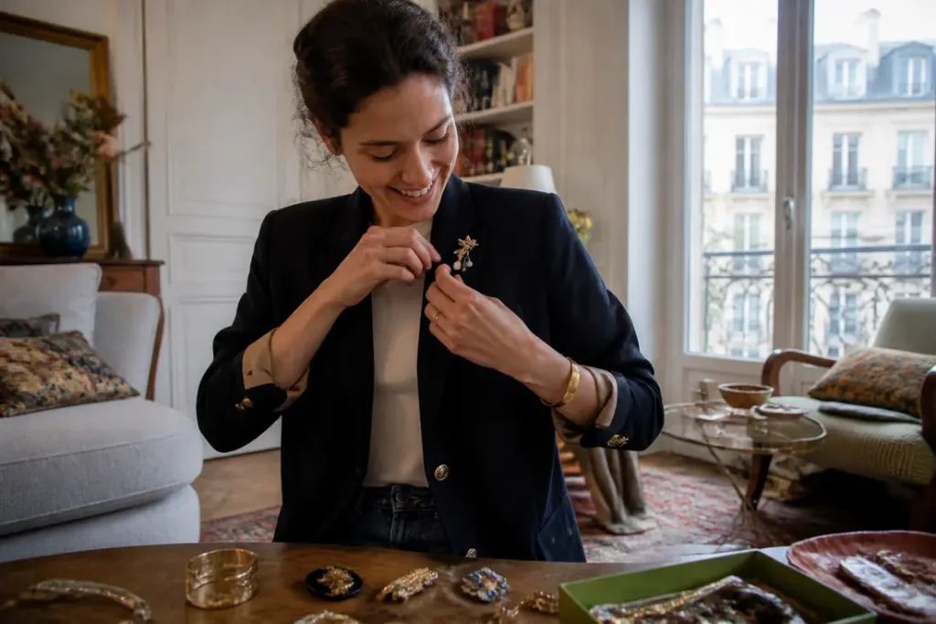Une jeune femme ajuste un accessoire audacieux sur sa tenue chic détail choc original dans un salon lumineux