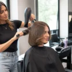 Une femme aux pointes incurvées découvre sa nouvelle bell bottom bob coupe chez le coiffeur.