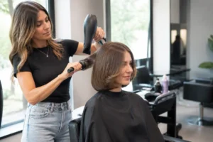 Une femme aux pointes incurvées découvre sa nouvelle bell bottom bob coupe chez le coiffeur.