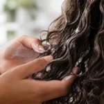 Quels soins pour cheveux bouclés et frisés ? Application d'une crème nourrissante sur les longueurs pour définir des cheveux bouclés.