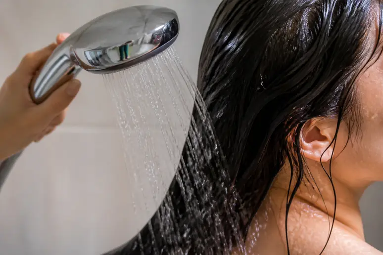 Rinçage soigneux d'un masque maizena cheveux sous l'eau tiède pour éliminer les résidus.