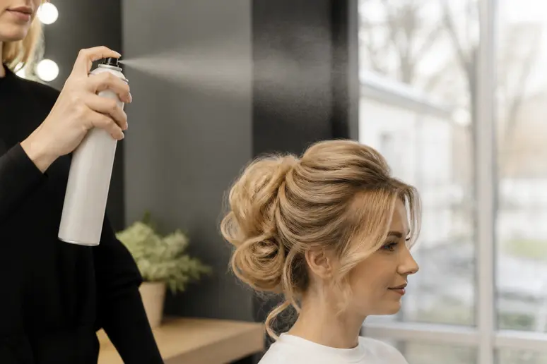 vaporisation d'un spray fixant léger à bonne distance pour préserver le volume et la souplesse