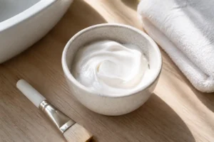 Un bol en céramique avec une pâte blanche pour un gommage enzymatique comment utiliser sur le visage