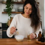 Femme préparant un soin capillaire avec une application huile de ricin cheveux dans sa cuisine