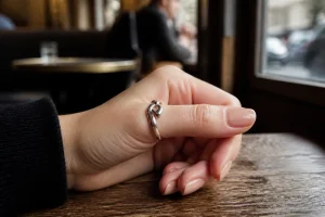 Gros plan sur une main élégante portant une signification bague au pouce en argent sur une table de café