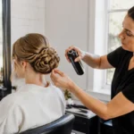 Un coiffeur professionnel réalise des tresses pour mariage soignées en salon avec des épingles et de la laque.